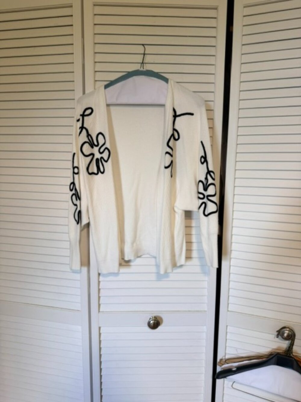White knit cardigan with black floral applique